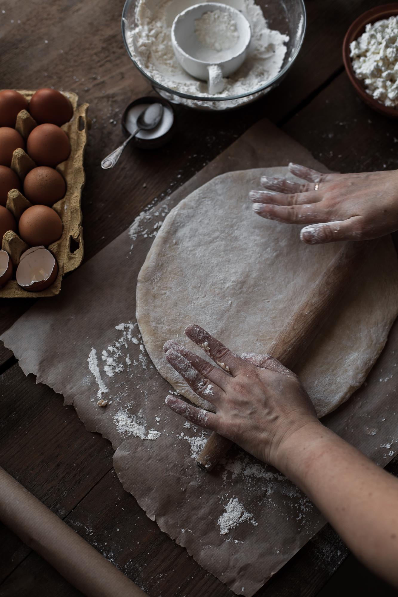 Close-up of hands kneading dough on wooden board